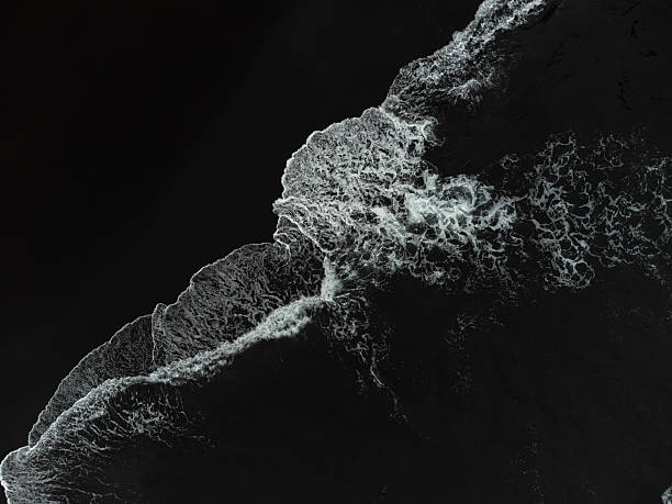 istock Drone view above a black sand beach from Atlantic Ocean with foamy white waves breaking on it. El Ancon Beach in Tenerife, Spain 2232246367