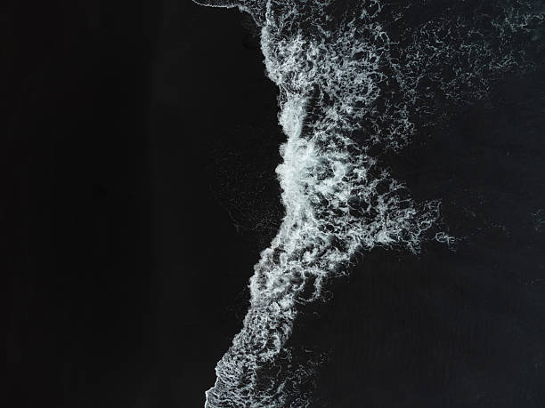 istock Drone view above a black sand beach from Atlantic Ocean with foamy white waves breaking on it. El Ancon Beach in Tenerife, Spain 2232246378