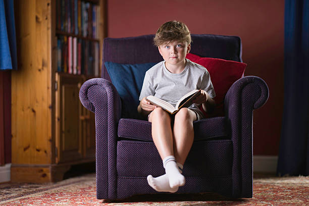 istock Primary age boy reading a book at home 2232248038