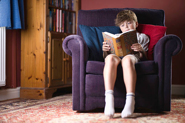 istock Primary age boy reading a book at home 2232251549
