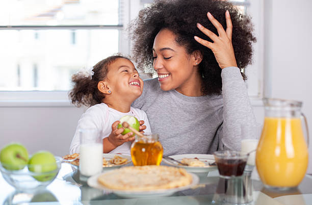 istock African-American young mother and daughter having breakfast 2232253775