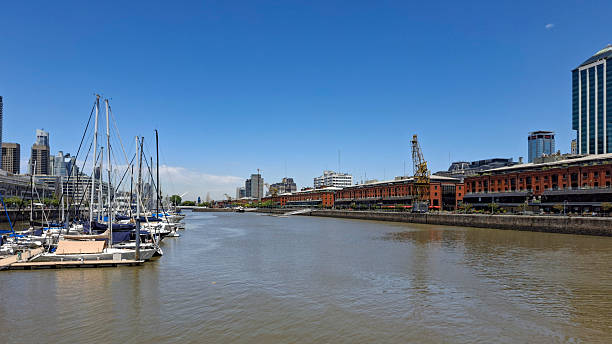 Buenos Aires, Argentina - March 13, 2020: Motorboat is sailing on the Riachuelo river near the Parque de la Costa amusement park in Tigre, Buenos Aires, Argentina, on a sunny day with blue sky