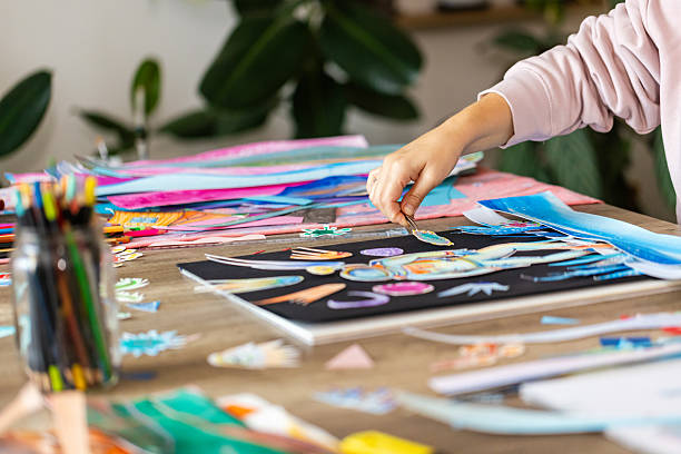 istock Woman creating art with paper cutouts 2232255703