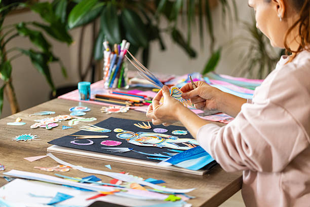 istock Woman creating art with paper cutouts 2232256031