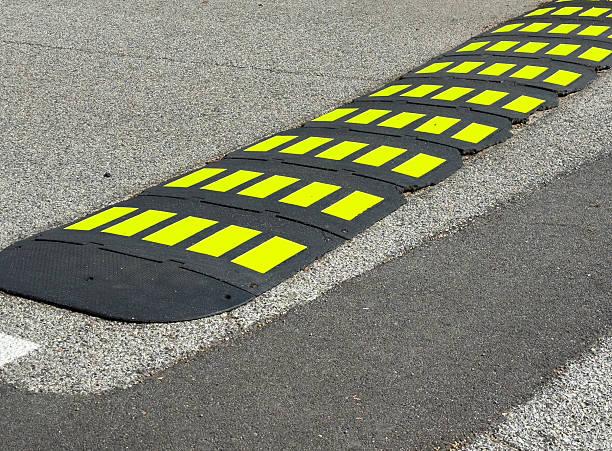 istock Yellow and black speed bump on asphalt road 2232256419