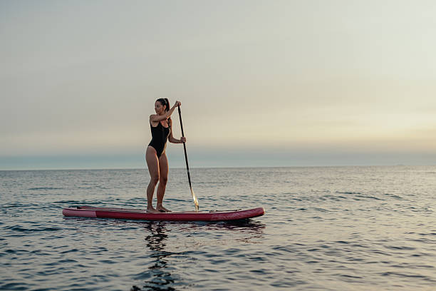 istock Woman paddling on a stand up paddle board at sunset 2232256810