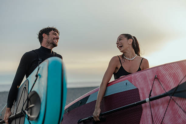 istock Couple laughing together after paddleboarding session at sunset 2232256817