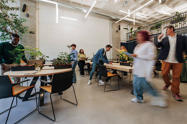 Modern coworking lounge with diverse people working on laptops and having discussions, featuring stylish furniture and decoration