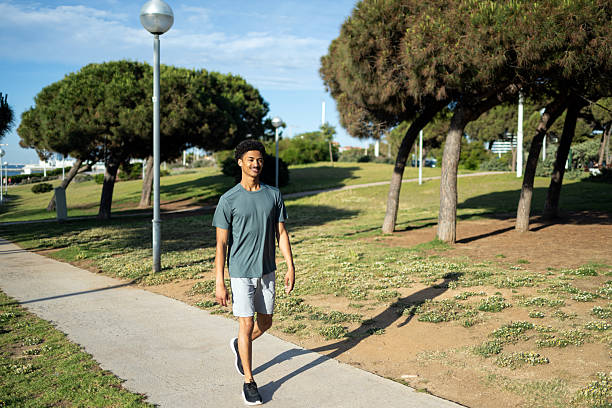 istock Young man walking in a park enjoying healthy lifestyle 2232256979