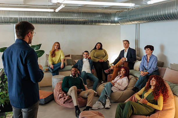 Diverse team listening to their creative director during a brainstorming meeting in a modern office