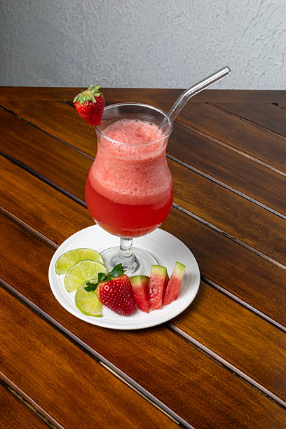 Healthy detox berry smoothie with fresh ingredients such as strawberry, watermelon, and lemon, a refreshing vegan drink for a healthy lifestyle and diet, served in a glass on a wooden table.
