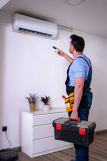 istock Handyman inspecting air conditioner unit with remote control in modern household setting 2232261448