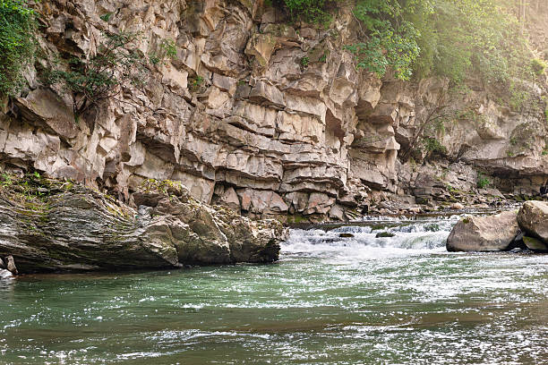 Mountain river. Rock hanging over the river. Rocky shore. Big stones in the mountains