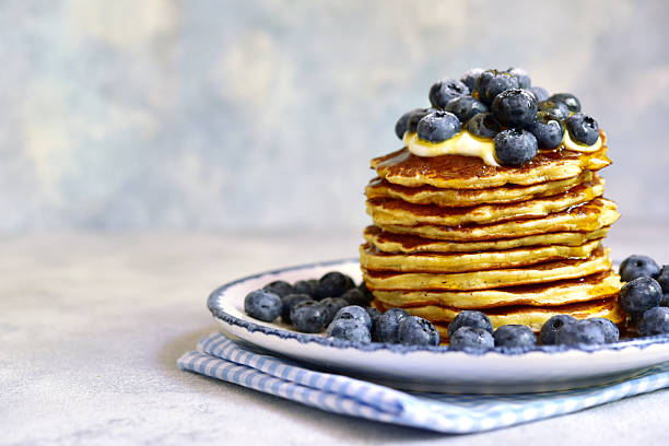 istock Stack of fresh hot banana pancakes with maple syrup and blueberries for a breakfast. 2232266963