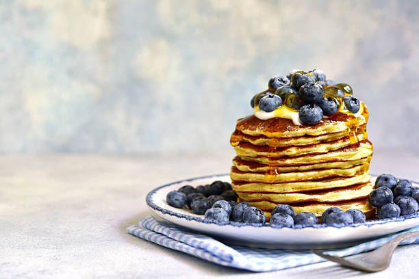 istock Stack of fresh hot banana pancakes with maple syrup and blueberries for a breakfast. 2232266976