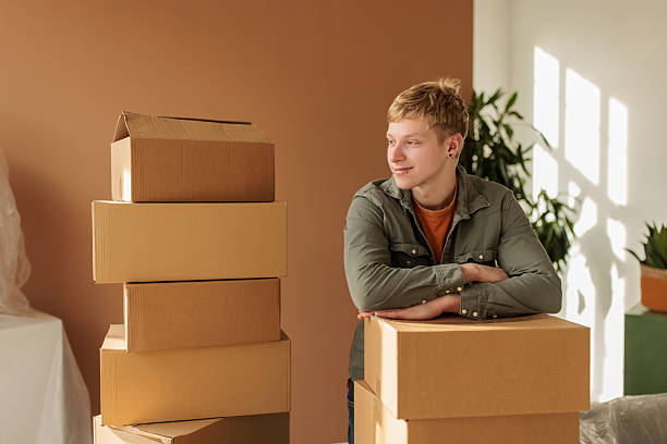 istock Young Man Standing in Living Room with Moving Boxes 2232267944