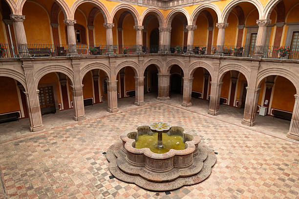 istock Elevated view of courtyard with central fountain, arched galleries and patterned tile floor in former monastery in Queretaro, Mexico 2232274323