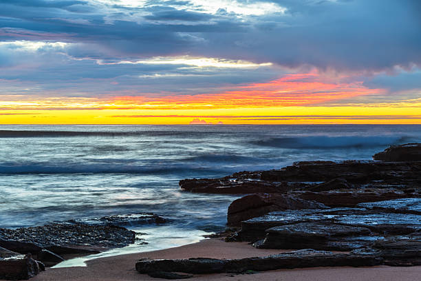 istock Winter sunrise by the sea shore with rain clouds 2232275006