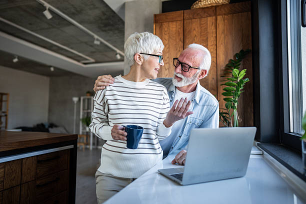 istock Happy senior couple using laptop at home and smiling 2232275549