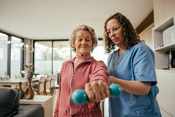 istock Elderly patient undergoing physical therapy with dumbbells - home consultation 2232288780