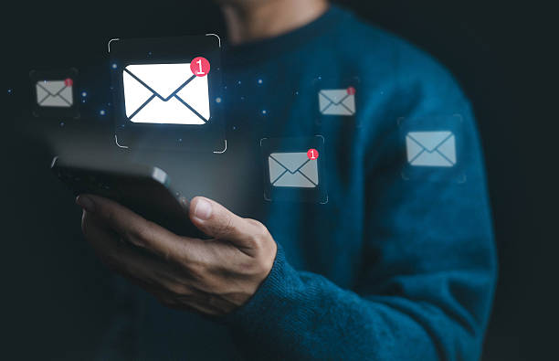 istock Person holding smartphone receiving new email notifications with message icons, symbolizing digital communication, online inbox, mobile mail, business contact, internet connection, and modern messaging. 2232289151