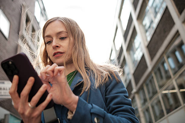 istock Young woman using smartphone walking in the city 2232290204