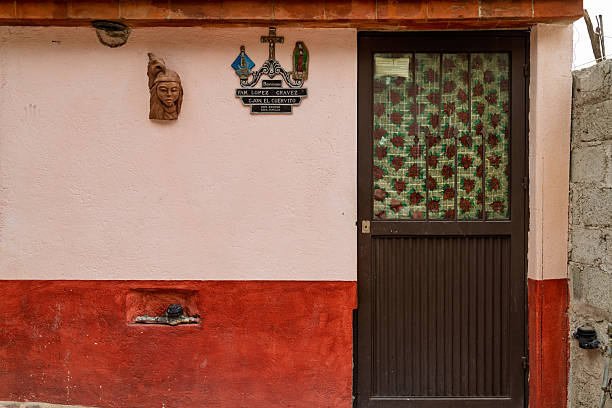 Bernal, Mexico – January 6, 2025: religious plaque and decorative door on residential facade