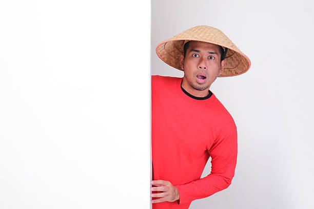 istock Indonesia farmer peeking behind wall showing shocked face expression 2232290797