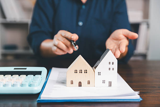 istock House model placed on table alongside coins, paperwork symbolizes real estate investment, property valuation, representing financial planning, mortgage options, market analysis in property business. 2232293006