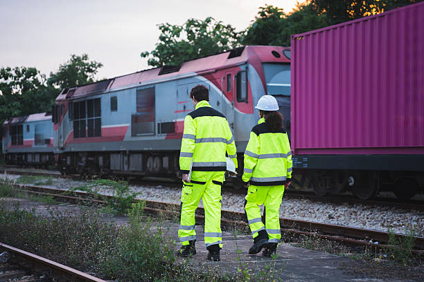 istock Logistics Team Overseeing Freight Operations at Rail Terminal, Engineers Supervising Cargo Containers at Industrial Train Yard, Workers Monitoring Transportation and Shipping at Railway Depot 2232293963