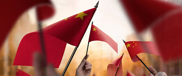 istock China flags in their hands on a blurred urban background 2232294600