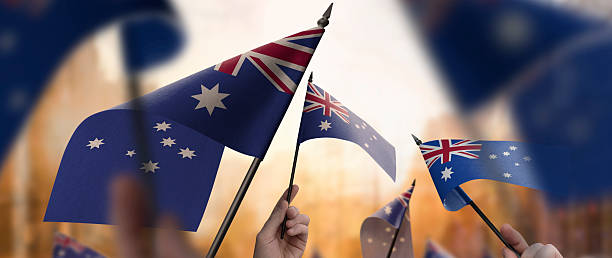 istock Australia flags in their hands on a blurred urban background 2232294609