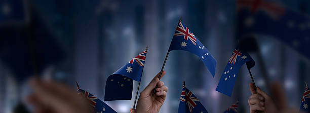 istock Australia flags in their hands on a blurred urban background 2232294624