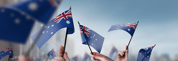 istock Australia flags in their hands on a blurred urban background 2232294642