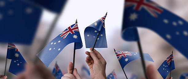 istock Australia flags in their hands on a blurred urban background 2232294675