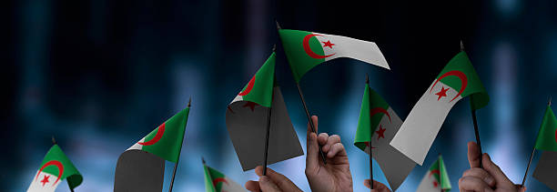 istock Algeria flags in their hands on a blurred urban background 2232294852