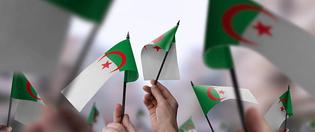 istock Algeria flags in their hands on a blurred urban background 2232294872