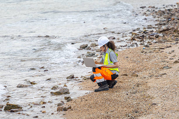 istock Female Environmental Engineer Testing Water Quality at Drainage Site, Field Scientists Collecting Water Samples near Industrial Area 2232298069