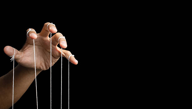 istock male puppeteer hand with strings isolated on black background. manipulation or controlling concept 2232298961