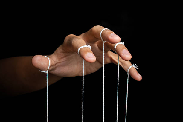 istock male puppeteer hand with strings isolated on black background. manipulation or controlling concept 2232298964