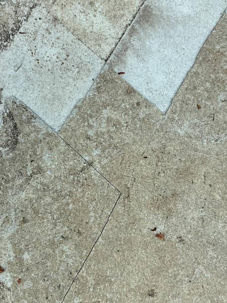 istock A cracked concrete sidewalk with a few leaves on it 2232301719