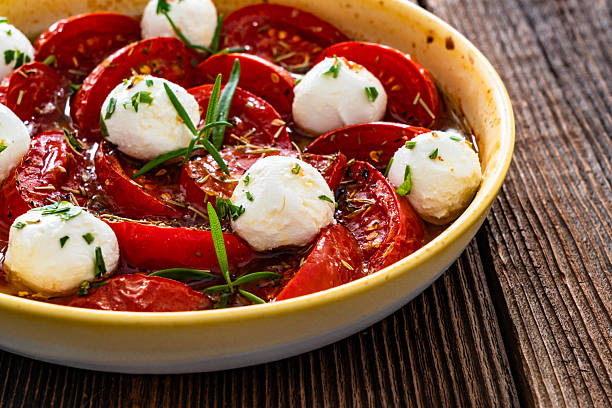 Roasted tomatoes and labneh cheese salad on wooden table