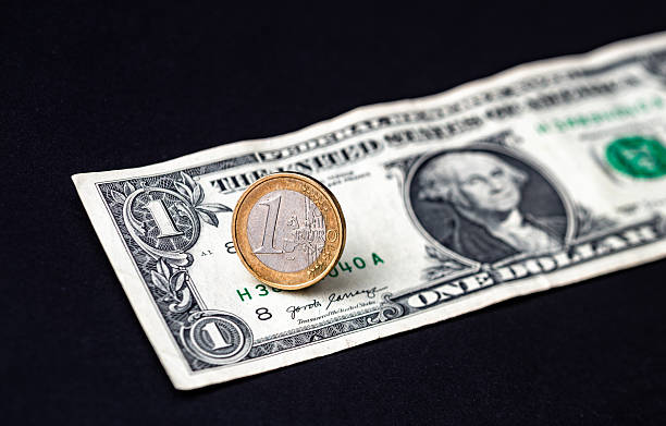 istock 1 Euro coin and 1 US dollar bill. 2232306569