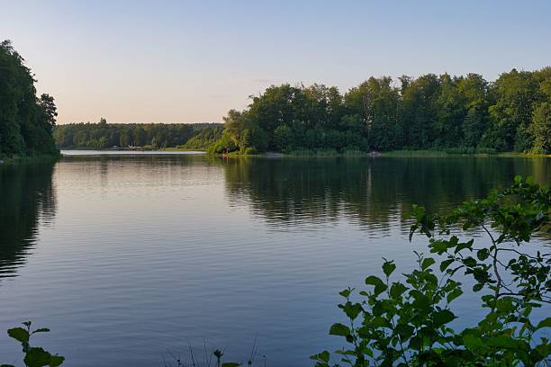 istock Tranquil lakeside view at dusk with lush greenery and calm waters in a serene location 2232307444