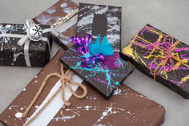 bunch of gifts wrapped in home made wrapping paper using different painting techniques and bows