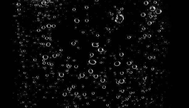 istock Clear water bubbles rising on black background, perfect for freshness, purity, abstract texture, science concepts, drink design, and creative digital backgrounds for modern projects. 2232313232