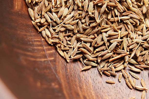 istock Dried cumin seeds on brown wooden texture. Aromatic spice. 2232315424