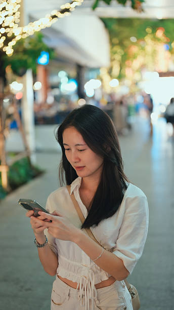 istock female professional connected with mobile technology AI during urban evening lifestyle 2232317373