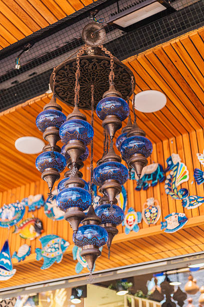 istock A stunning array of blue glass lamps dangles from above, showcasing intricate patterns and craftsmanship. The backdrop includes vibrant handmade art pieces, enhancing the lively atmosphere 2232317539