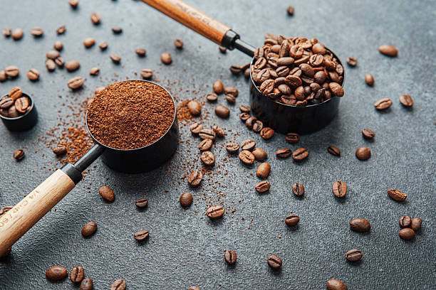 istock Ground coffee and whole beans with scoops on gray background 2232321375